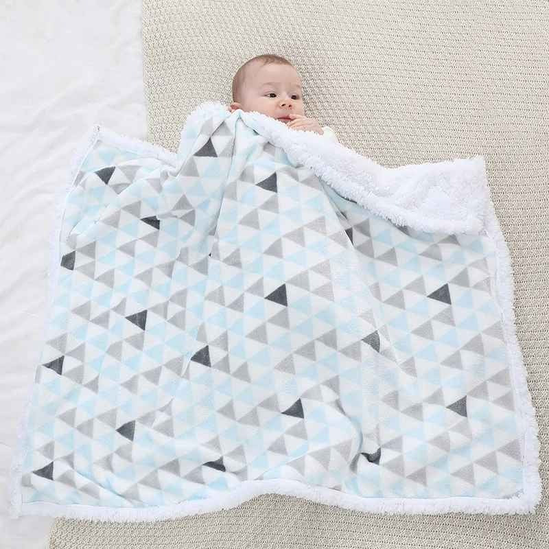 Bébé allongé couvert avec couverture bébé motifs triangles bleu Chaudoudou