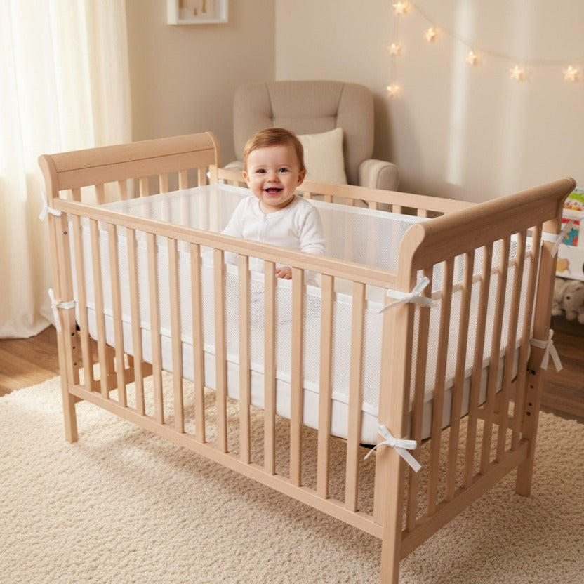 Bébé assit dans berceau protégé par tour de lit respirant AirSafe