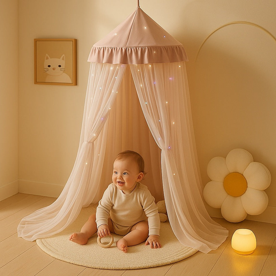 Bébé assit heureux sous Voile de lit bebe rose Cocon Apaisant