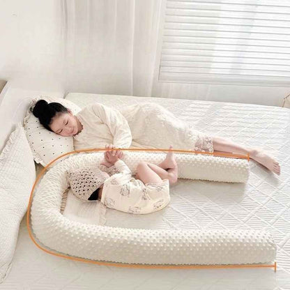 Bébé dormant paisiblement avec maman entouré d'un tour de lit pour bebe Nid Protecteur
