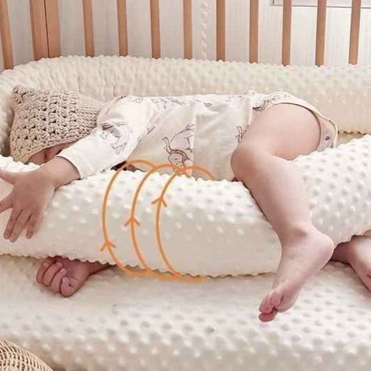Bébé dormant paisiblement dans son berceau blotti a un tour de lit pour bebe Nid Protecteur