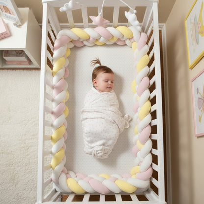 Bébé dort dans berceau avec tresse de lit bébé cozyknot rose jaune