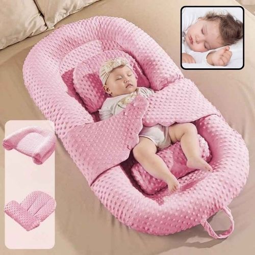 Bébé dort paisiblement dans Réducteur de lit évolutif rose Cocoon Doux