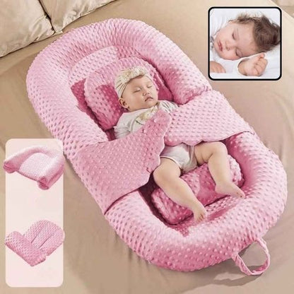 Bébé dort paisiblement dans Réducteur de lit évolutif rose Cocoon Doux