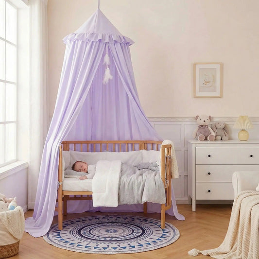 Bébé dort paisiblement dans son lit avec ciel de lit pour berceau Cocon Magique