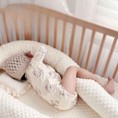 Bébé dort paisiblement tenant tour de lit pour bebe entre jambes Nid Protecteur