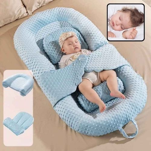 Bébé fille dort paisiblement dans Réducteur de lit évolutif bleu Cocoon Doux