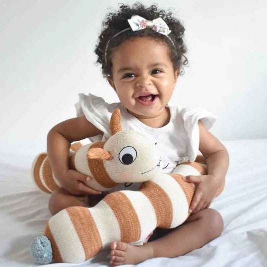 Bébé fille souriante enroule autour d'elle tour de lit bébé chenille Douceur Protectrice