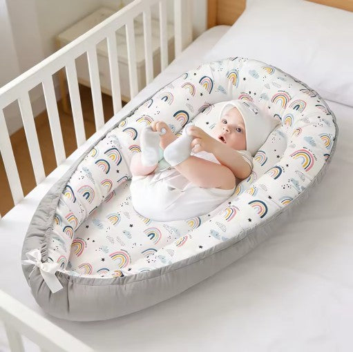 Bébé joue confortablement dans cocon bébé nidportablebebe arc-en-ciel