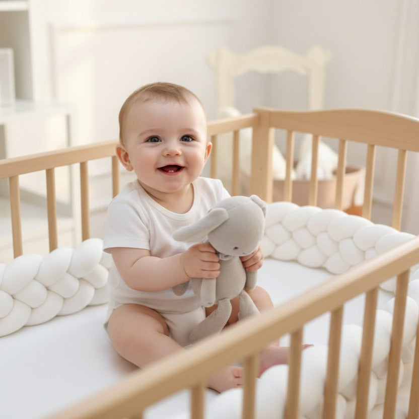 Bébé souriant assit dans becreau avec tresse de lit 3m LovliNest