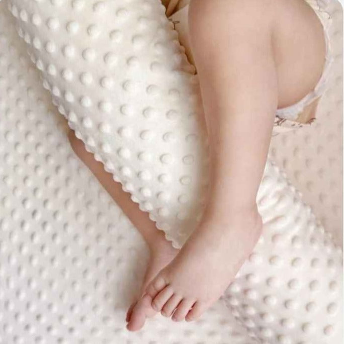 Jambes de bébé sur la texture douce d'un tour de lit pour bebe Nid Protecteur
