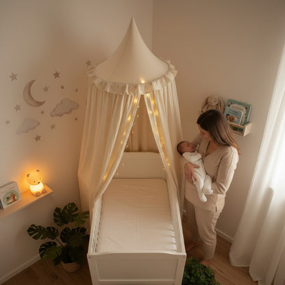 Maman pose bébé dans berceau avec ciel de lit bébé beige féerique
