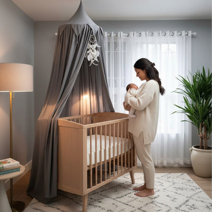 Maman pose bébé dans berceau avec ciel de lit bébé gris nuage