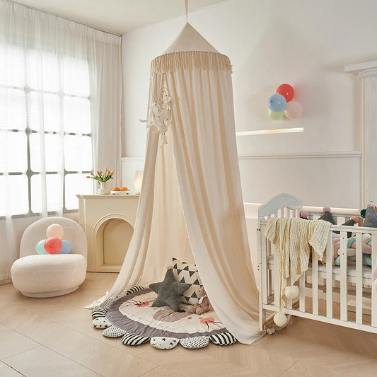 Voile pour berceau beige suspendu dans chambre bébé avec coin jeu Cocon Protecteur