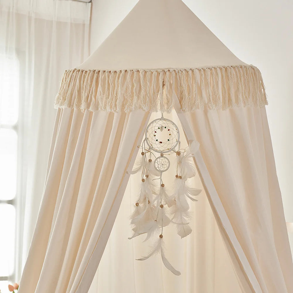 Vue rapprochée sur voile pour berceau beige avec franges décoratives et attrape rêves Cocon Protecteur