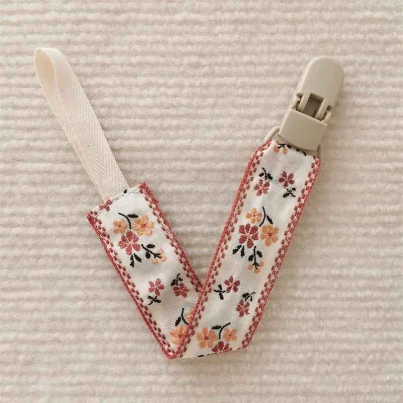 Attache tetine fleurs rouges Sécurité Stylée