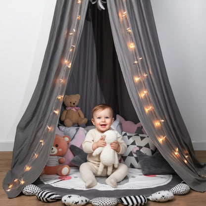 bébé assit souriant sous ciel de lit  bébé gris nuage