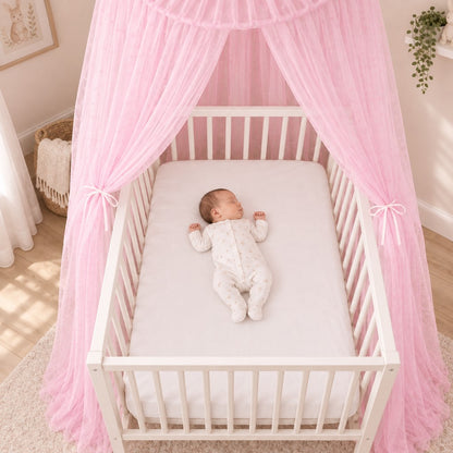 bébé fait sieste dans berceau sous ciel de lit fille rose blush