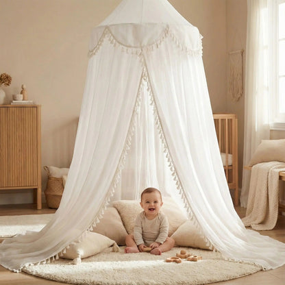 bébé souriant assit sous voile pour lit bebe dans chambre Cocon Apaisant