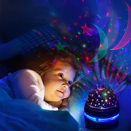 Bébé souriant regarde la veilleuse bébé projection plafond - Douce Nuit