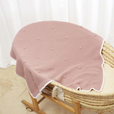 Couverture bébé douce tricotée rose sur lit La Maillette