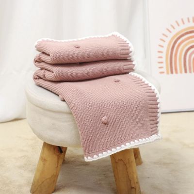 Couverture bébé douce tricotée rose sur tabouret La Maillette