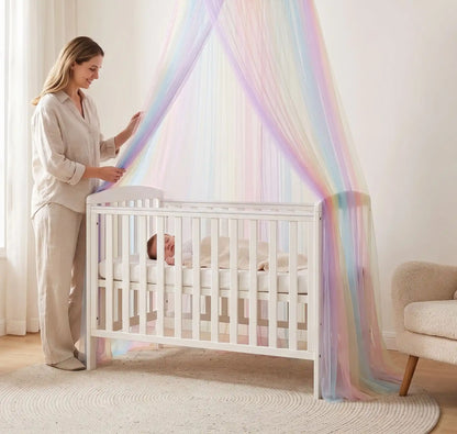 maman souriante ajuste ciel de lit bébé - arc-en-ciel